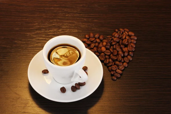 Taza de café sobre mesa de madera sobre fondo marrón — Foto de Stock