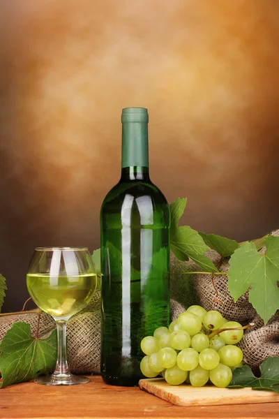 瓶与棕色背景上的木桌上的玻璃大酒 — 图库照片