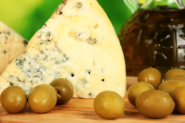 Composição de queijo azul e azeitonas em fundo verde brilhante close-up — Fotografia de Stock