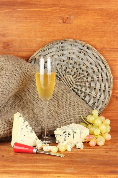 Composição de queijo azul e um copo de vinho com uvas em fundo de madeira close-up — Fotografia de Stock