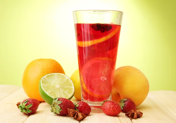Osvěžující sangria sklenice s ovocem, na dřevěný stůl, na zeleném pozadí — Stock fotografie