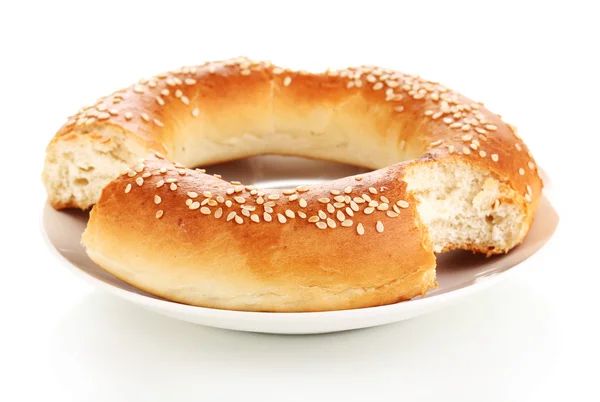 Bitten bagel with sesame seeds on plate isolated on white — Φωτογραφία Αρχείου