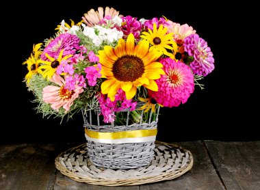 Beautiful bouquet of bright flowers on wooden table on black background clipart