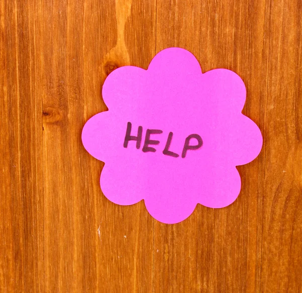 Help written on sticker on wooden background — Stock Photo, Image