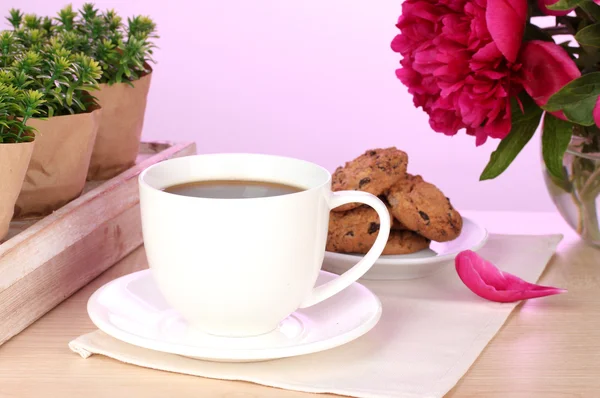 Tasse de café, biscuits et fleurs sur la table dans le café — Photo