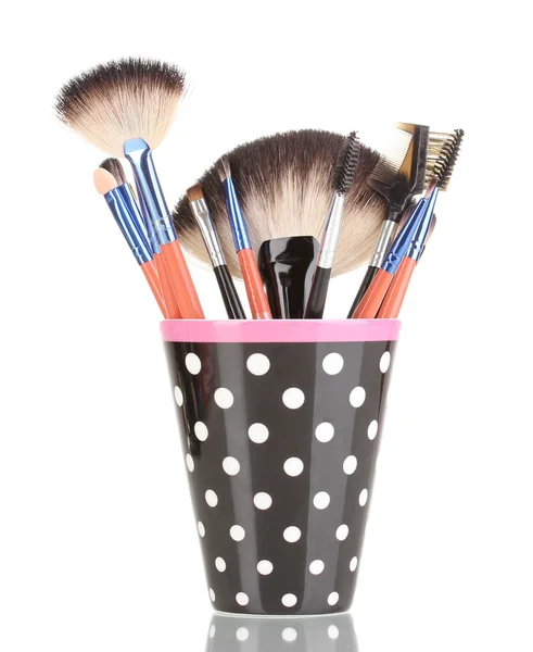 Make up borstels in een polka-zwarte kop geïsoleerd op wit — Stockfoto