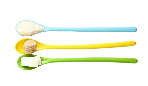 Colheres coloridas brilhantes com diferentes tipos de açúcar isolado em branco — Fotografia de Stock