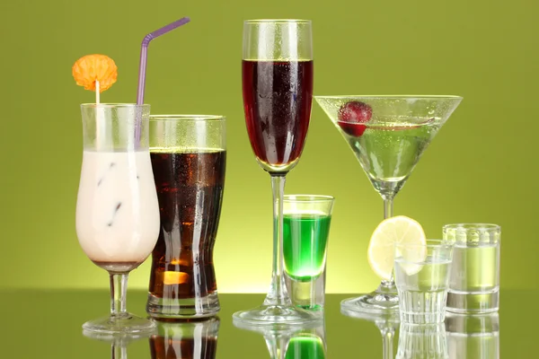 O varietate de băuturi alcoolice pe fundal verde — Fotografie, imagine de stoc