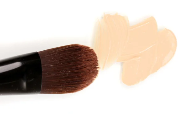 Base cosmética líquida y cepillo aislado en blanco — Foto de Stock