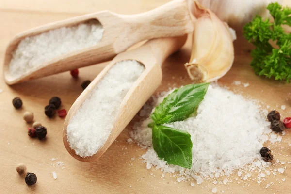 Salz mit frischem Basilikum und Petersilie, Knoblauch und Pfeffer auf Holztisch — Stockfoto