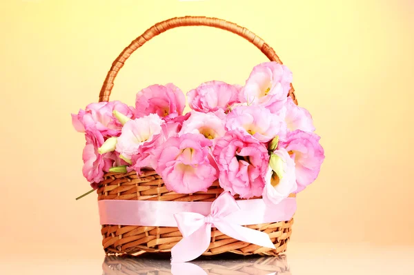 Bukiet eustoma kwiaty w koszyku, na żółtym tle — Zdjęcie stockowe