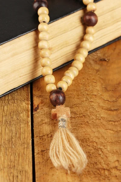 Les perles de chapelet en bois et la bible sainte sur fond en bois close-up — Photo