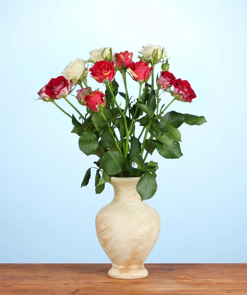 Όμορφα τριαντάφυλλα στο βάζο σε κοντινό πλάνο μπλε φόντο — Φωτογραφία Αρχείου