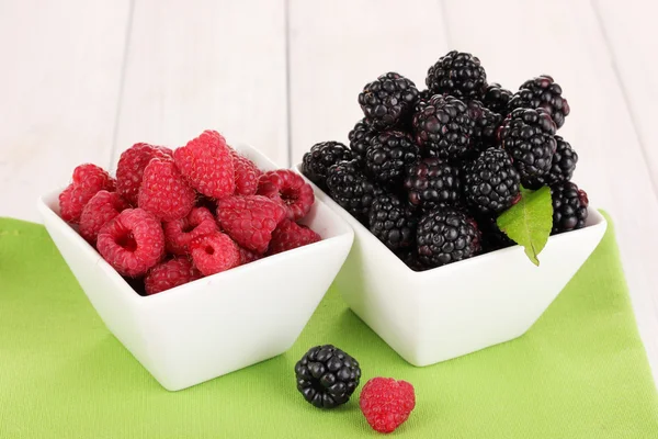 Ripe raspberries and brambles on wooden table — Stock Photo, Image