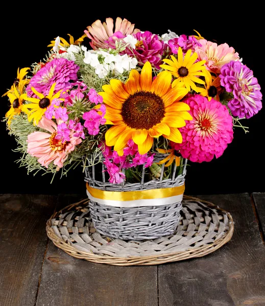 stock image Beautiful bouquet of bright flowers on wooden table on black background