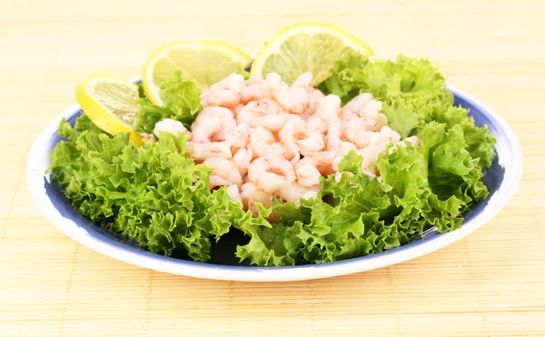 Delicious marinated shrimp in plate on bamboo mat — Stock Photo, Image