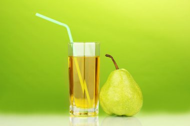 Pear juice in a glass on green background