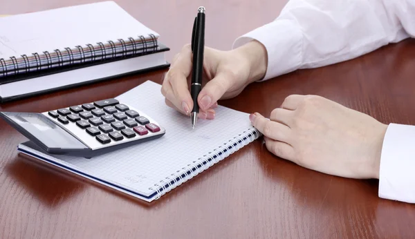 Women hands with pencil, notebooks and Calculator on wooden table — Stock Photo, Image