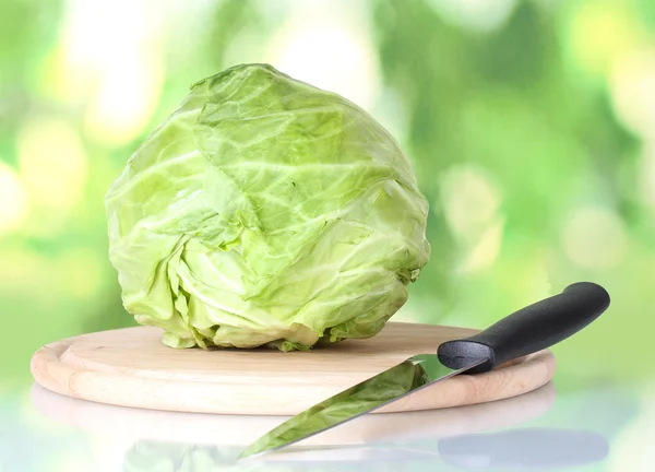Yeşil renkli arka plan üzerinde bıçak ile kesme tahtası lahana — Stok fotoğraf
