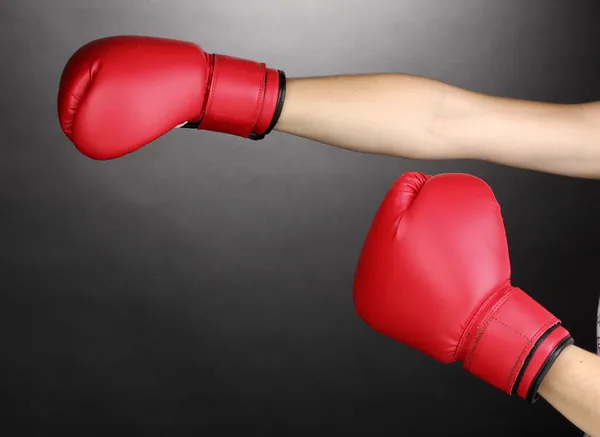 Rote Boxhandschuhe an den Händen auf grauem Hintergrund — Stockfoto