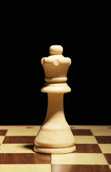 Schackbräde med schackpjäs isolerade på svart — Stockfoto