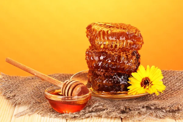 Honungskaka på träbord på orange bakgrund — Stockfoto