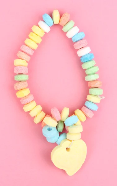 Color candies on rope on pink background — Stock Photo, Image