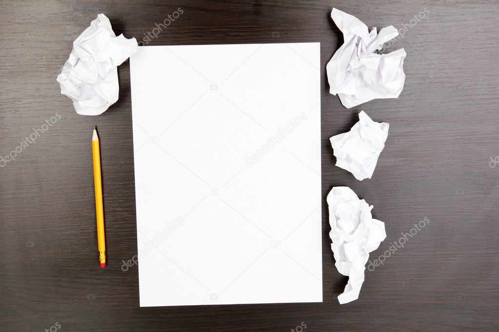 Empty paper, crumpled paper and pencil on wooden table