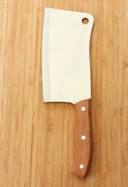 Meat cleaver on wooden background close-up clipart