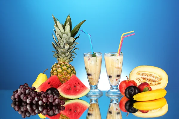 Milk shakes with fruit on blue background close-up
