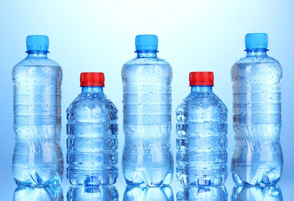 Пластиковые бутылки воды на синем фоне — стоковое фото