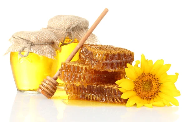 Sweet honeycombs, jars with honey, wooden drizzler and sunflower, isolated on white — Stock Photo, Image