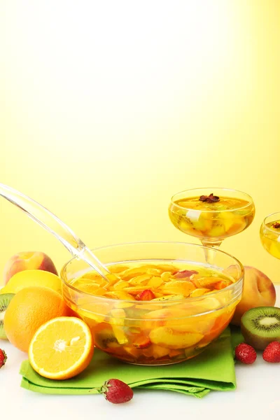 Soco na tigela e copos com frutas, no fundo amarelo — Fotografia de Stock