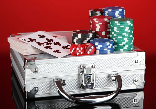 Poker impostato su un caso metallico su sfondo rosso brillante — Foto Stock