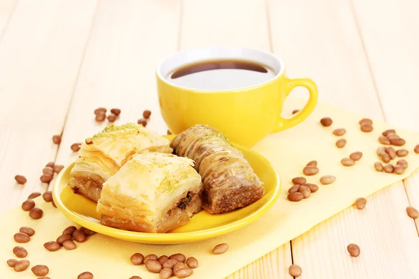 Сладкая пахлава на тарелке с чаем на деревянном фоне — стоковое фото