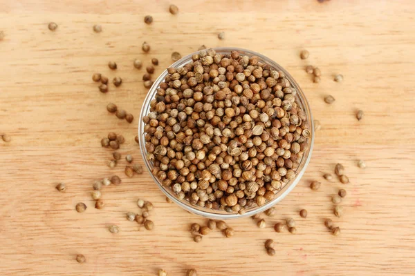 Heap sementes de coentro em tigela no fundo de madeira close-up — Fotografia de Stock