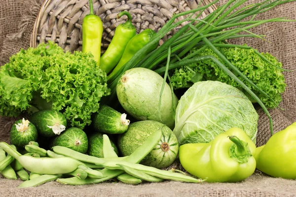Verse groene groenten op rouwgewaad achtergrond — Stockfoto