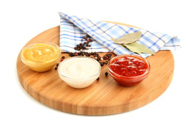 Various sauces on chopping board isolated on white clipart