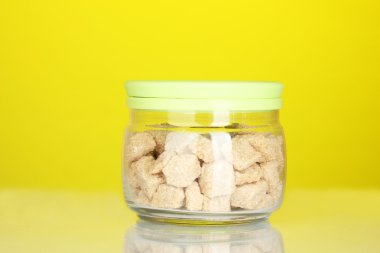 renkli arka plan üzerinde kahverengi şeker kamışı yumru ile jar