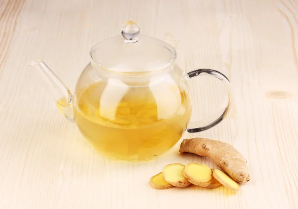 Healthy ginger tea in kettle on wooden background — Stock Photo, Image