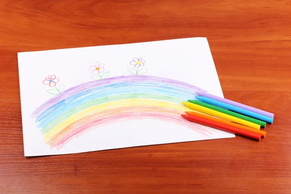 Детский рисунок радуги и карандашей на деревянном фоне — стоковое фото