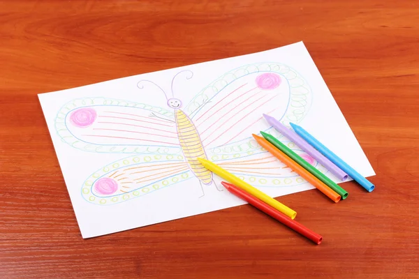 Children's drawing of butterfly and pencils on wooden background — Stock Photo, Image