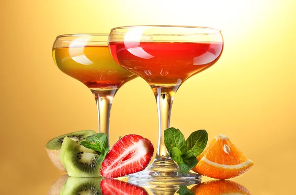 Gelée de fruits dans des verres et des fruits sur fond jaune — Photo