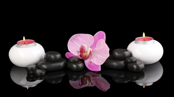 Piedras de spa con flor de orquídea y velas aisladas en negro — Foto de Stock