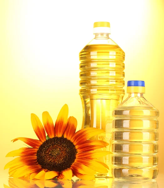 Solrosolja och solrosor på gul bakgrund — Stockfoto