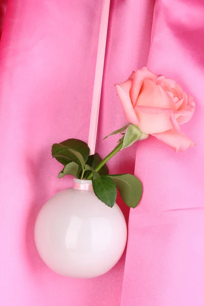 Piękna róża w wazonie wiszące na szmatką tło — Zdjęcie stockowe