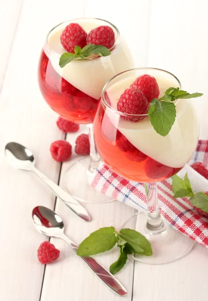 Fruit jelly with raspberries in glasses on wooden table — Stock Photo, Image