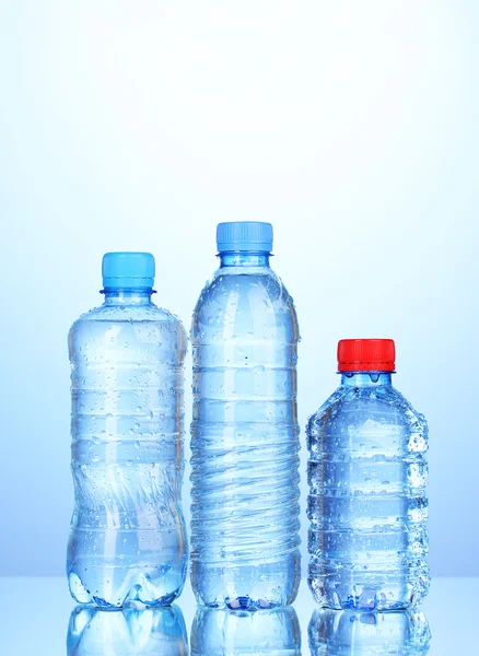 Пластиковые бутылки воды на синем фоне — стоковое фото