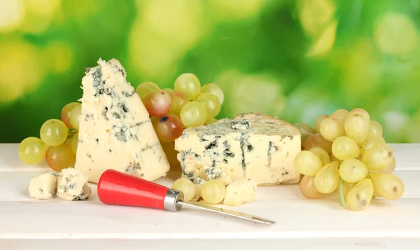 Composição de queijo azul e uvas em fundo verde close-up — Fotografia de Stock