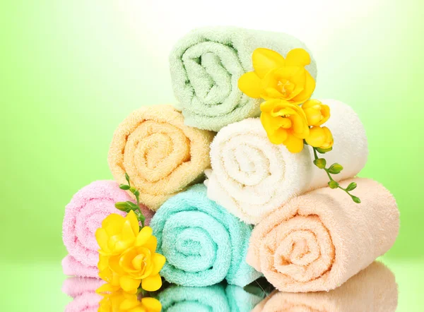 Färgglada handdukar och blommor på grön gul bakgrund — Stockfoto